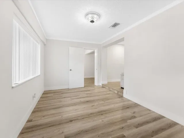 a view of empty room with wooden floor