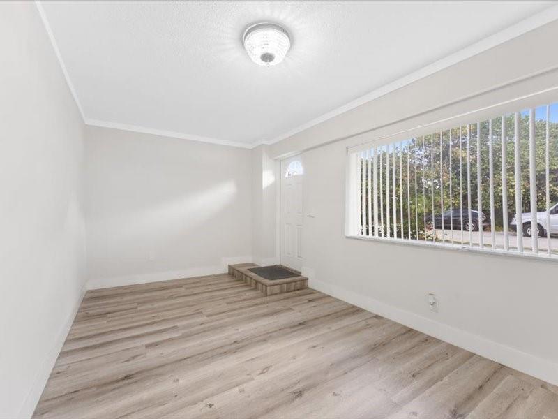 311 West Sample Road Deerfield Beach, FL 33064 - Photo 8 of 34 a view of empty room with wooden floor and fan