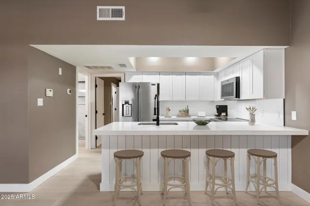 a large white kitchen with a sink and cabinets