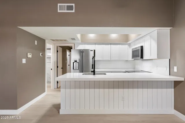 a large white kitchen with a sink