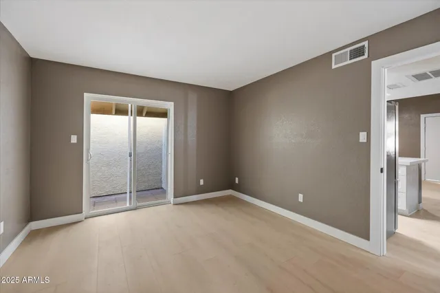 an empty room with mirror in closet and a potted plant