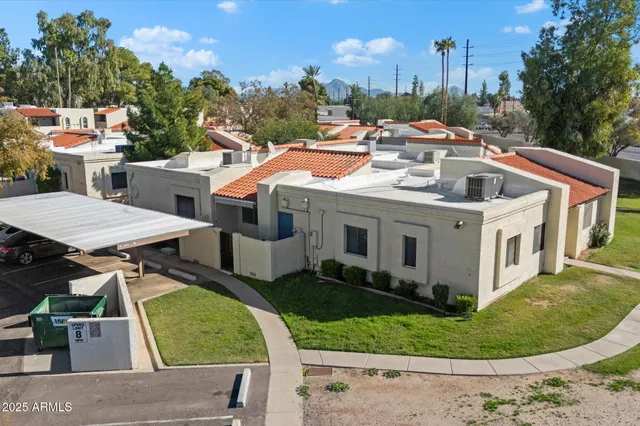 a view of a white house with a sink and a yard