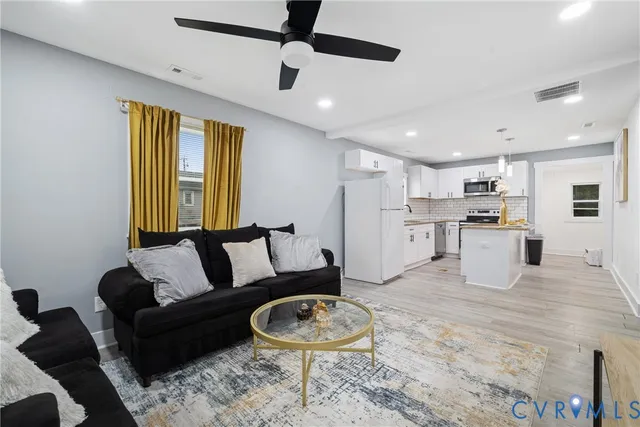 a living room with furniture and a wooden floor
