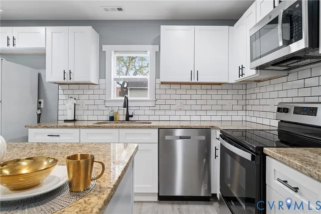 a kitchen with a stove and white cabinets