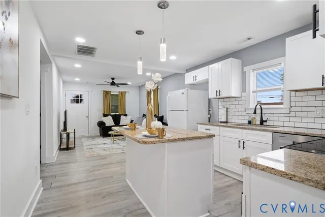 a kitchen with sink refrigerator and cabinets