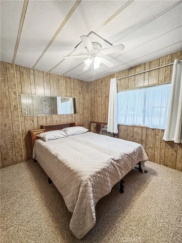 a bed sitting in a spacious bedroom next to a window