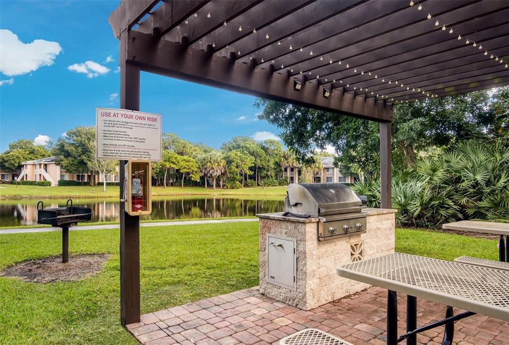 4248 Southeast Cove Lake Circle, Unit 3B06207 Stuart, FL 34997 - Photo 14 of 18 a patio with a yard table and chairs