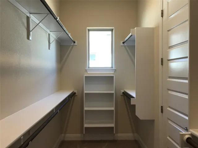 a view of walk in closet with empty racks