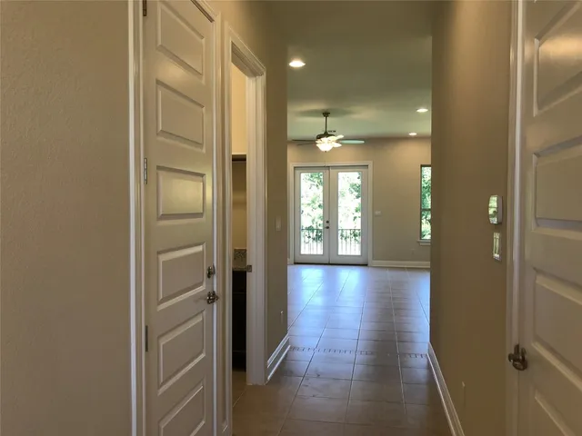 a view of a hallway with wooden floor and glass door