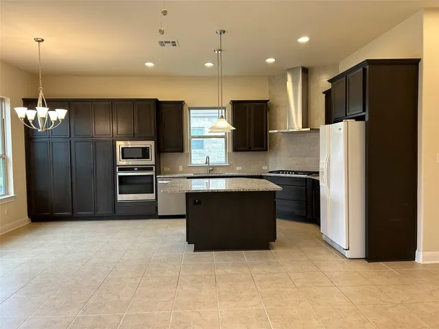 a kitchen with kitchen island stainless steel appliances a refrigerator and a microwave