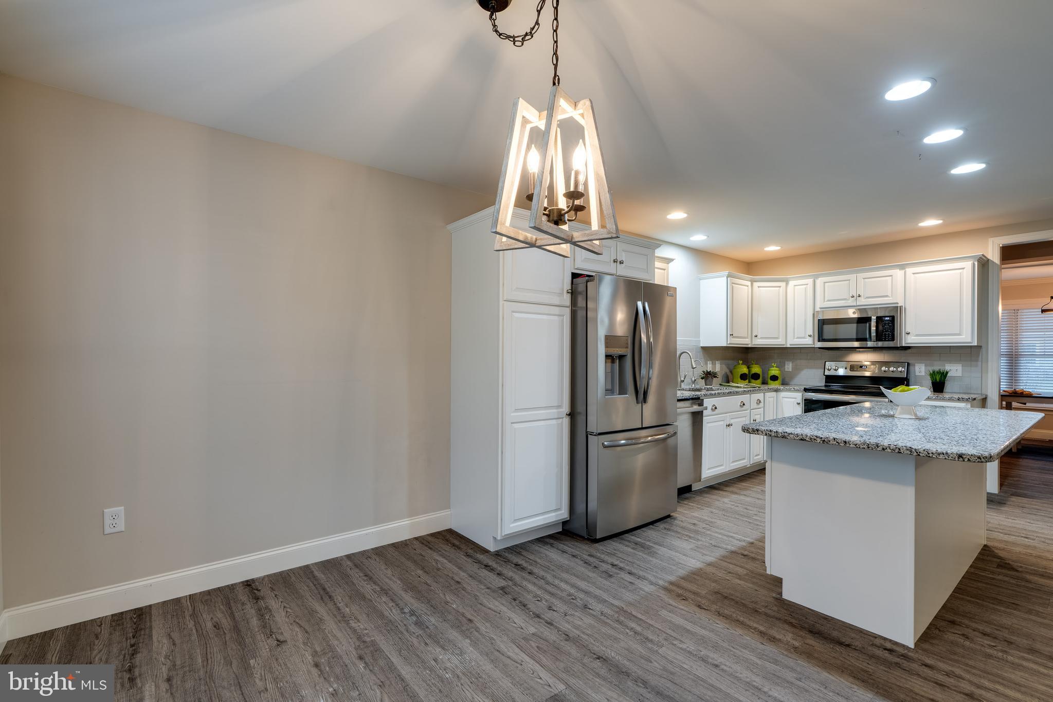 1400 Limestone Ridge Landisville, PA 17538 - Photo 21 of 50 a kitchen with stainless steel appliances a refrigerator a stove top oven a sink dishwasher and a dining table with wooden floor