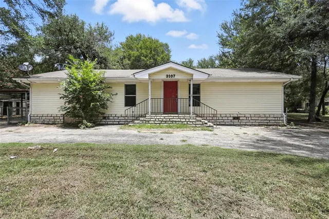 a view of a house with backyard and trees