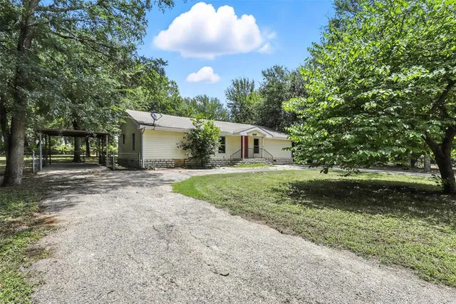 a front view of a house with a garden and yard