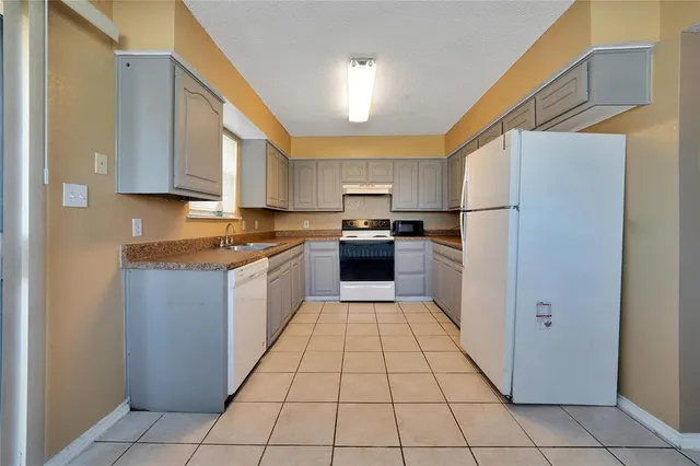 a kitchen with a cabinets a sink and a stove top oven