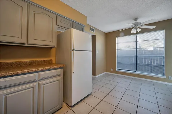 a view of a kitchen with refrigerator and cabinets