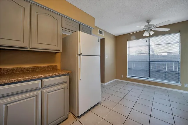 a view of a kitchen with refrigerator and cabinets