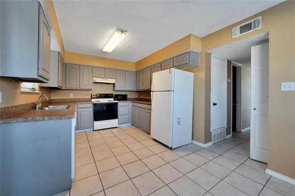 a kitchen with a cabinets a refrigerator and a sink
