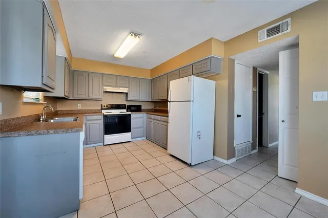 a kitchen with granite countertop a sink and a stove