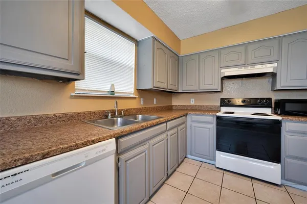 a kitchen with granite countertop a sink and a stove