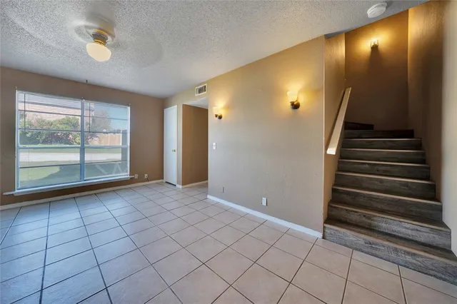 a view of an empty room with a fireplace and a window