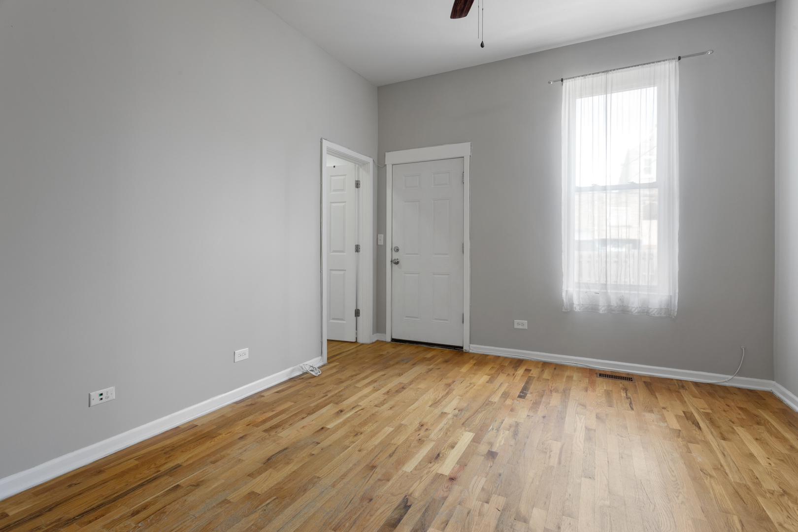 1532 West 18th Place, Unit 1R Chicago, IL 60608 - Photo 10 of 12 a view of an empty room with wooden floor and a window