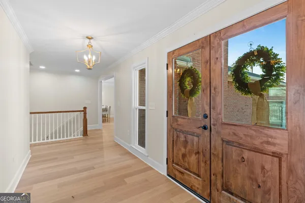 a view of an empty room with wooden floor and window