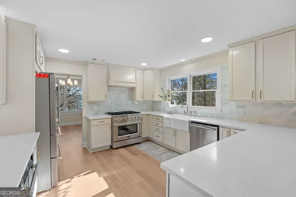 a kitchen with stainless steel appliances granite countertop a sink a stove and a refrigerator