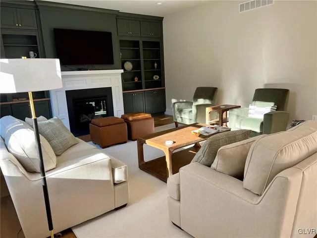 a living room with furniture a flat screen tv and a fireplace