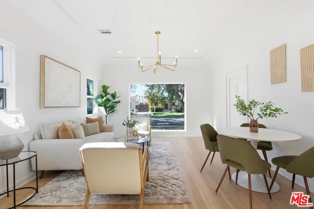 a living room with furniture dining table and a chandelier