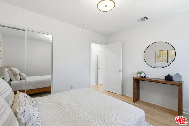 a bedroom with bed and a mirror