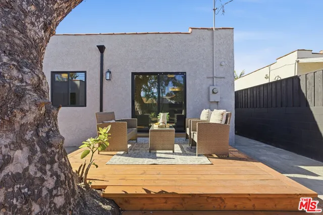 a view of a patio with table and chairs and wooden floor