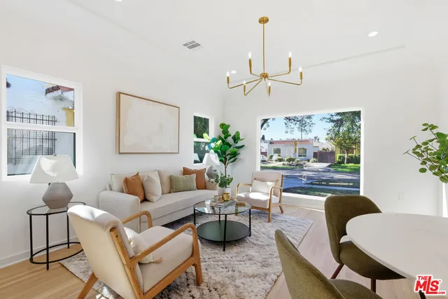 a living room with furniture a chandelier and a window