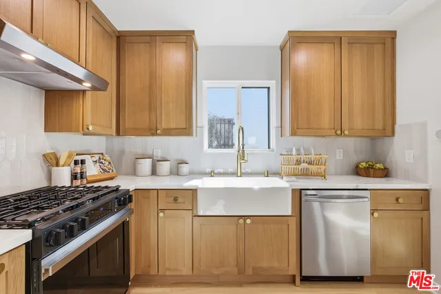 a kitchen with stainless steel appliances granite countertop a stove a sink and a refrigerator