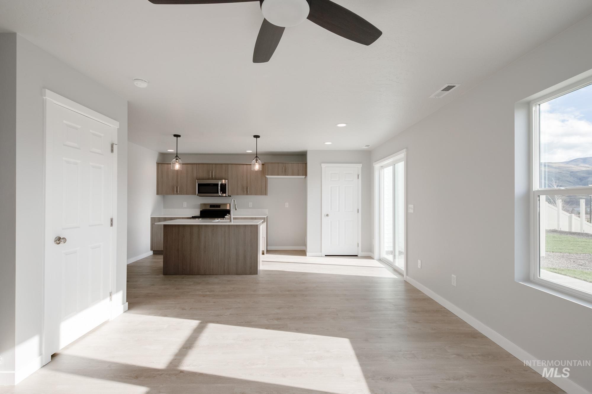 229 Moose Street Horseshoe Bend, ID 83629 - Photo 26 of 27 Kitchen featuring light countertops, a center island with sink, open floor plan, appliances with stainless steel finishes, and hanging light fixtures