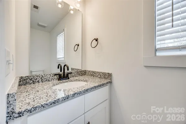 a bathroom with a granite countertop sink and a mirror