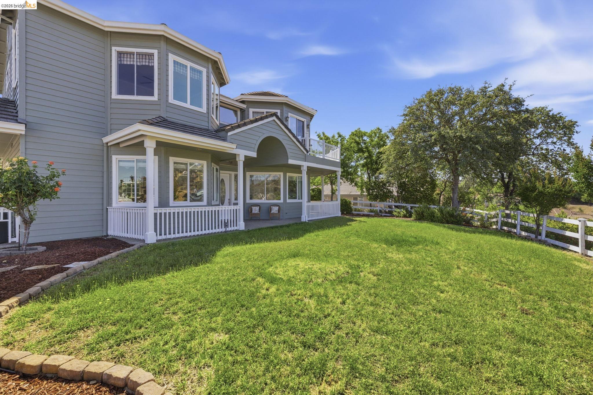 6242 Bluff View Road Copperopolis, CA 95228 - Photo 49 of 59 Expansive green lawn with a white picket fence bordering mature trees