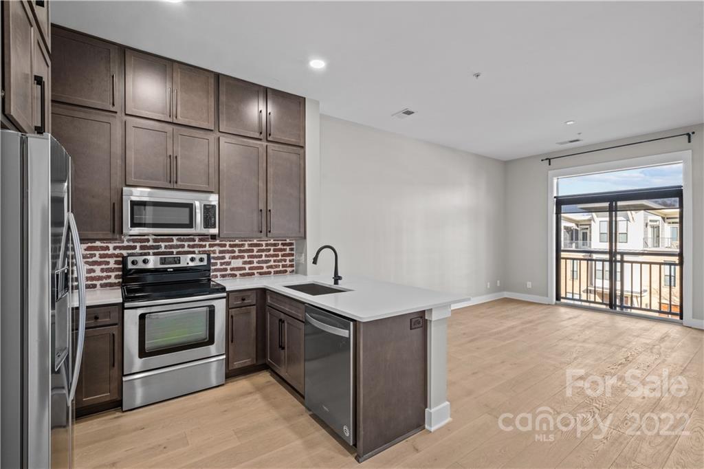 a kitchen with stainless steel appliances granite countertop a sink stove and refrigerator