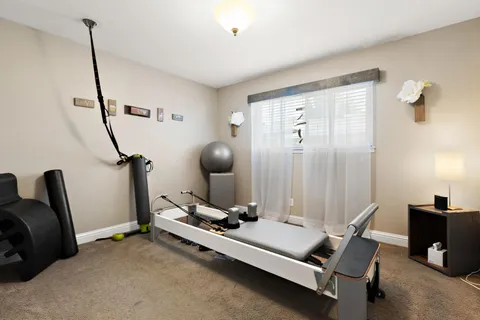 a room with gym equipment and a chandelier