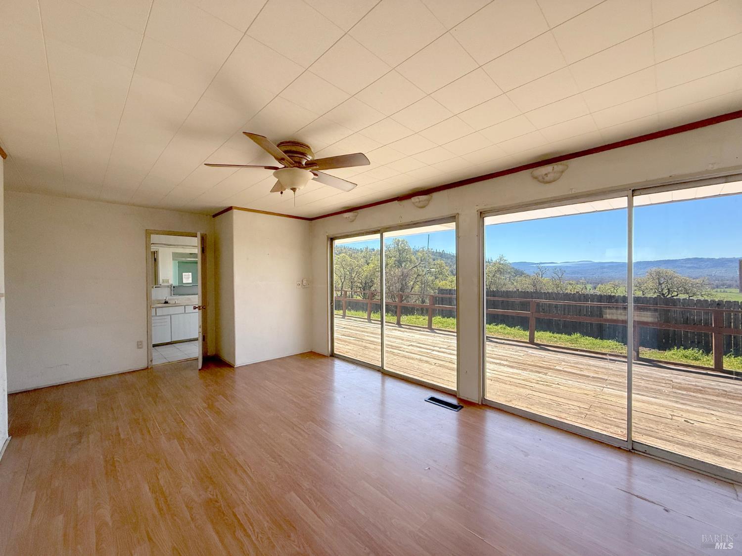 27150 Mendocino Pass Road Covelo, CA 95428 - Photo 10 of 32 an empty room with wooden floor and a floor to ceiling window