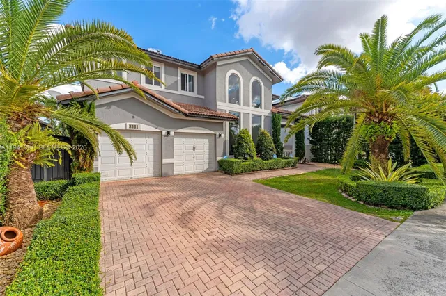 a front view of a house with a garden and trees