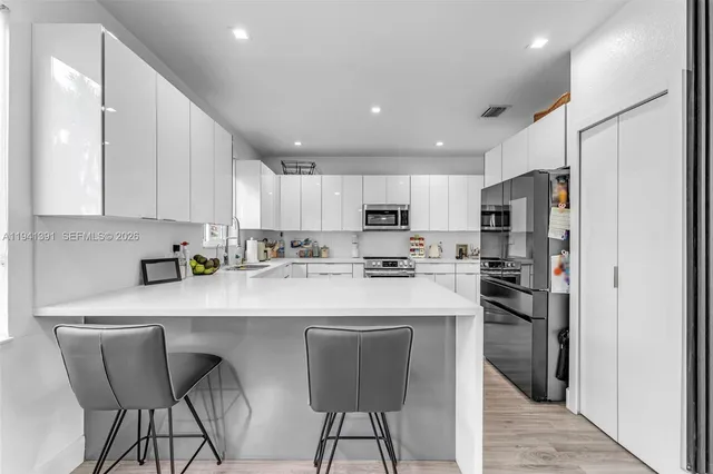 a kitchen with stainless steel appliances granite countertop a refrigerator and a stove top oven