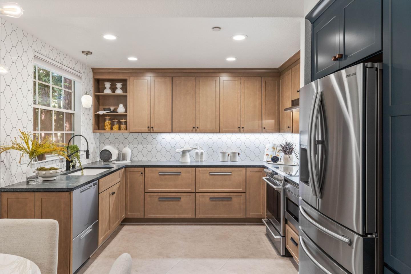 a kitchen with stainless steel appliances granite countertop a sink stove and refrigerator