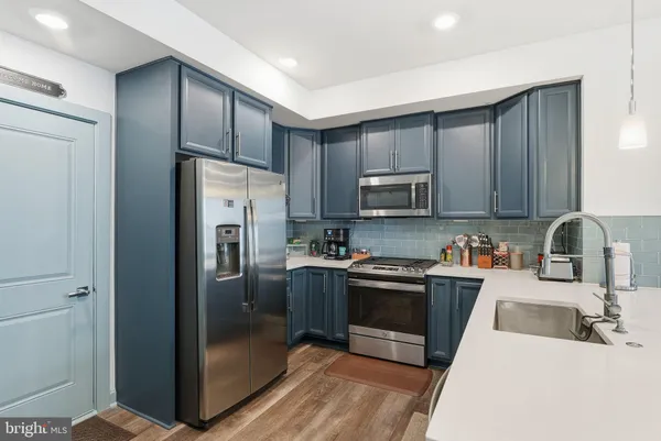 a kitchen with stainless steel appliances granite countertop a refrigerator stove top oven and sink