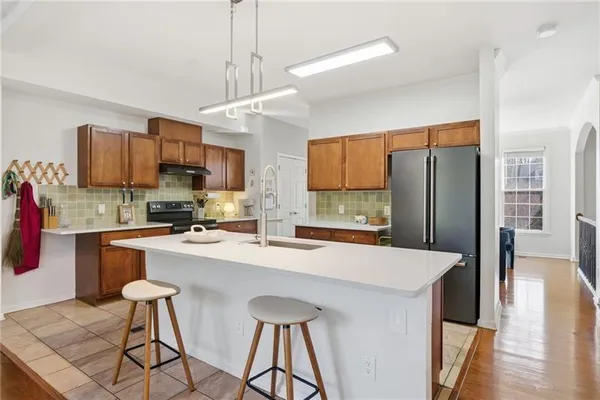 a kitchen with stainless steel appliances a sink stove refrigerator and cabinets
