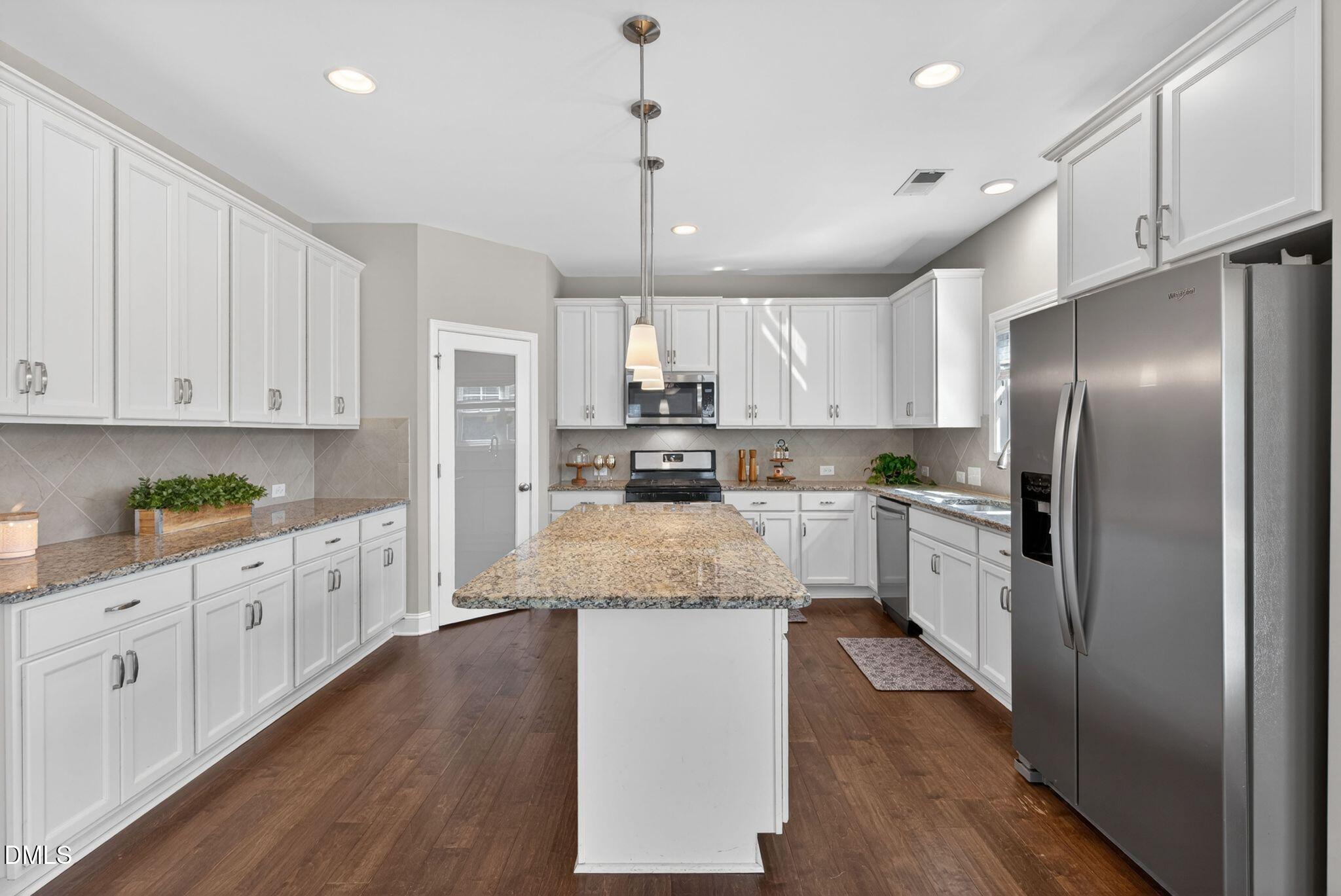 164 East Ravano Drive Clayton, NC 27527 - Photo 11 of 30 a large kitchen with granite countertop a center island stainless steel appliances and cabinets