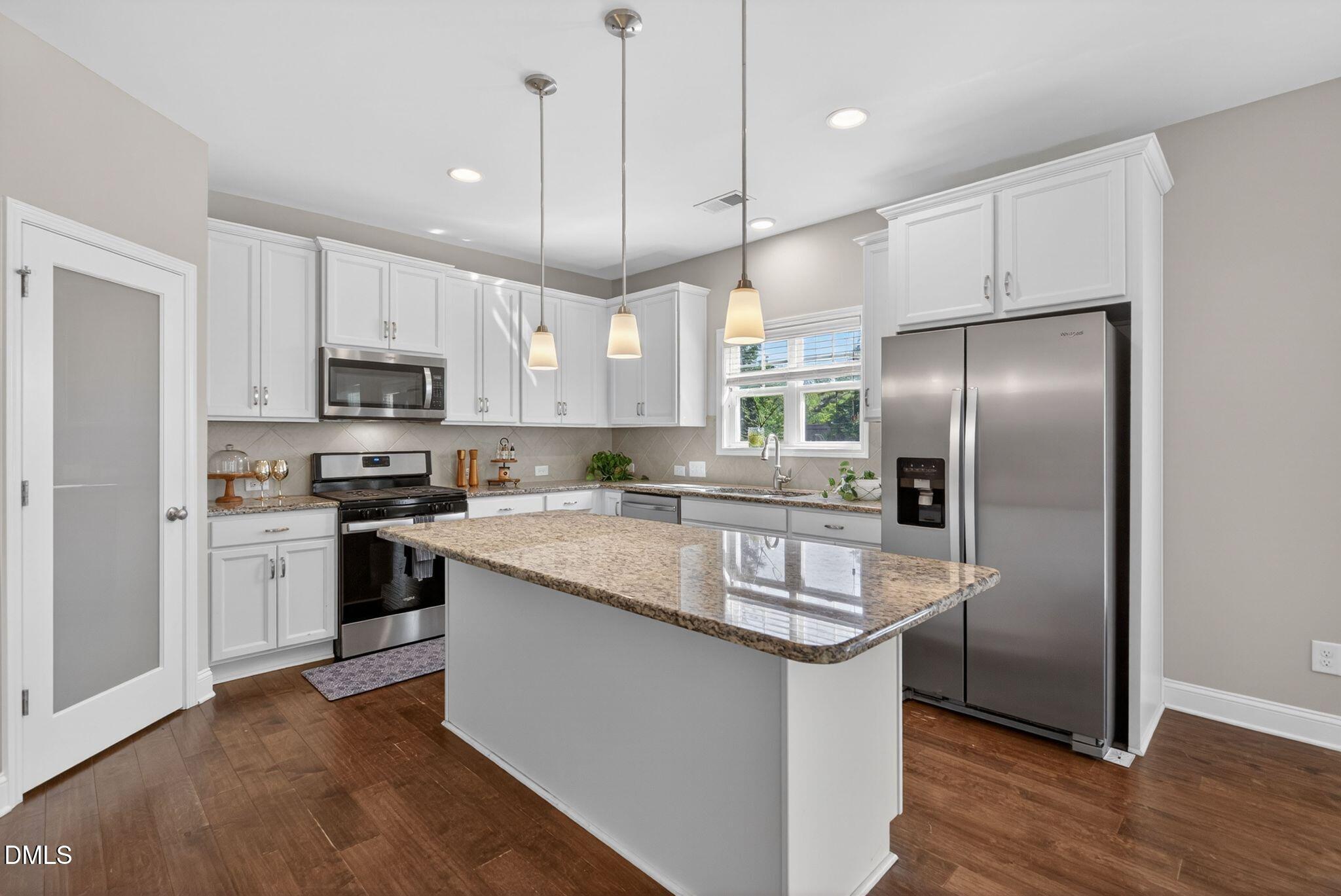 164 East Ravano Drive Clayton, NC 27527 - Photo 12 of 30 a kitchen with kitchen island granite countertop stainless steel appliances a refrigerator a stove a sink and a center island