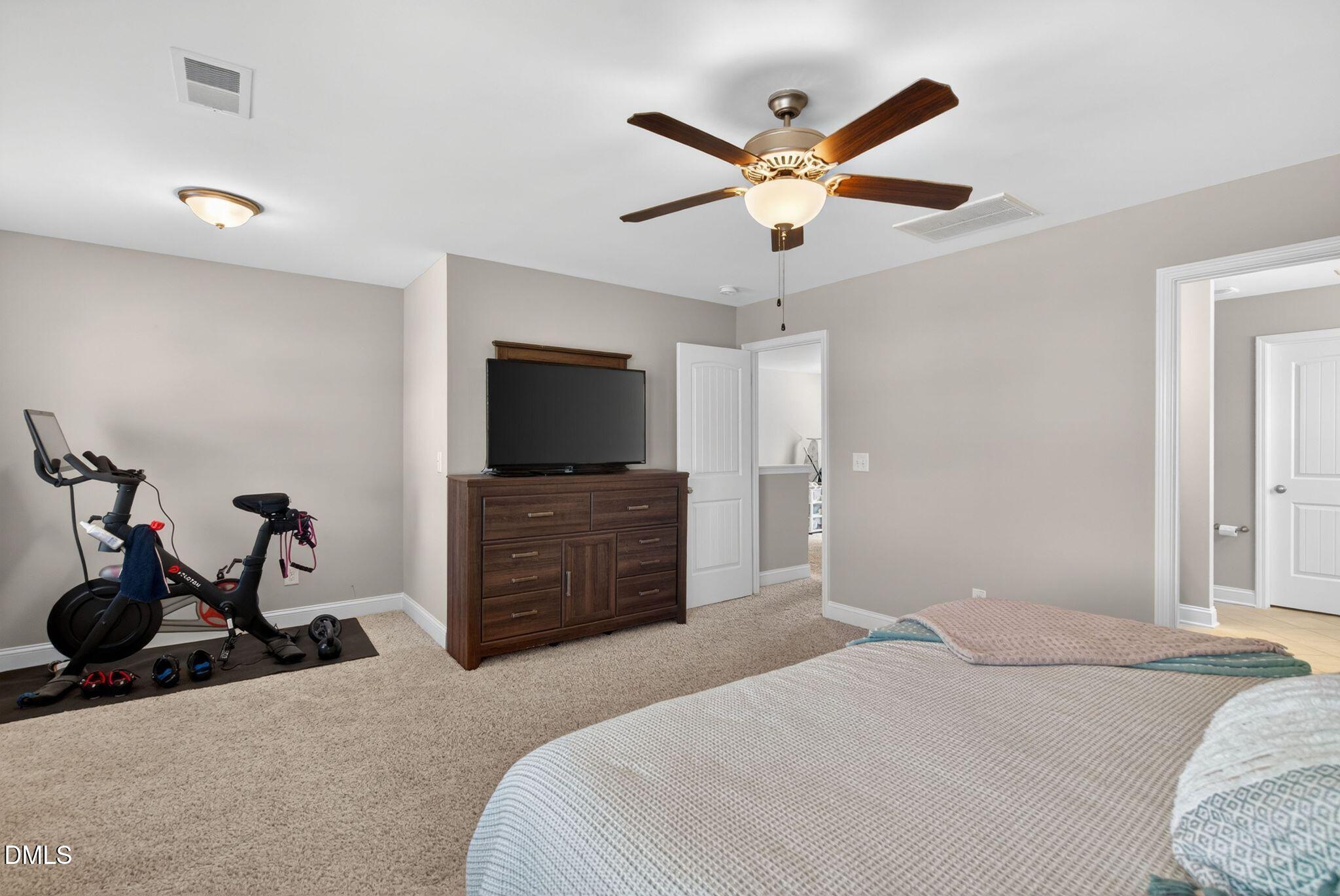 164 East Ravano Drive Clayton, NC 27527 - Photo 21 of 30 a bedroom with a bed and a flat screen tv