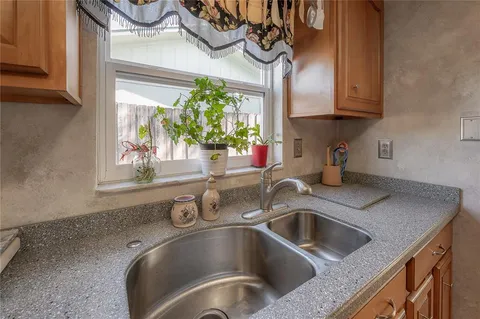 a kitchen with a sink cabinets and a window