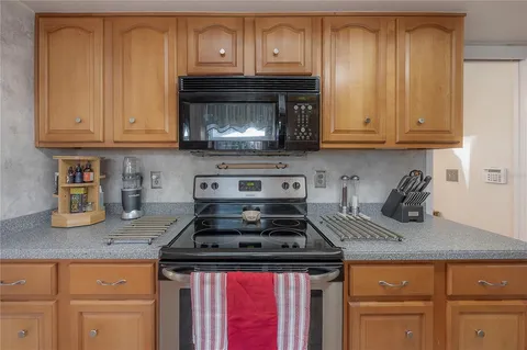 a kitchen with granite countertop wood cabinets and stainless steel appliances