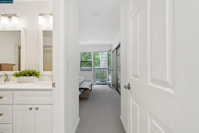a view of a hallway with a livingroom and a bathroom